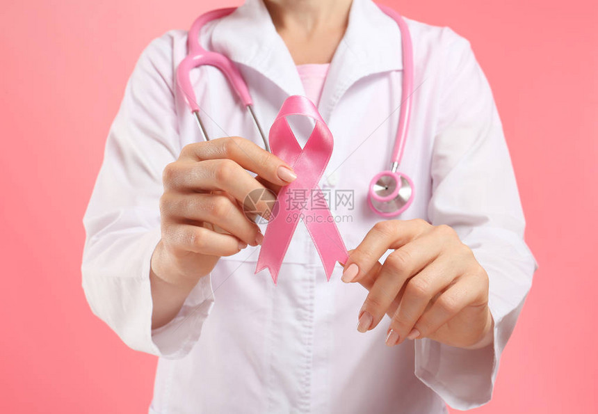 医生在彩色背景上贴着粉红色丝带乳图片