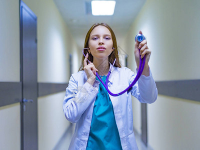 在医院走廊里拿着听诊器的女医生图片