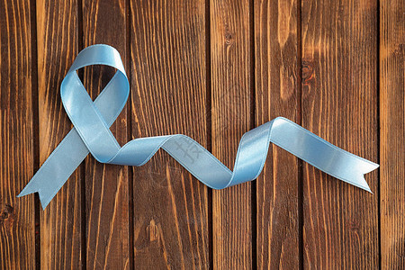 木制背景上的蓝丝带前列腺癌概念图片