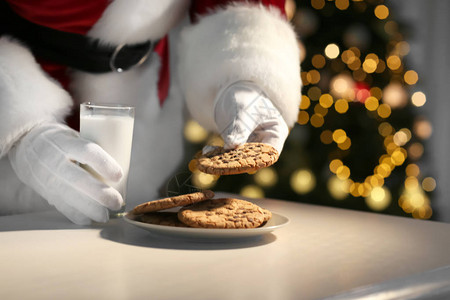 圣诞老人在餐桌上吃饼干和图片