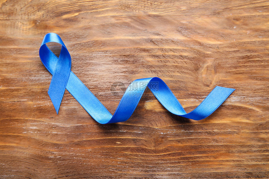 木制背景上的蓝丝带癌症概念图片