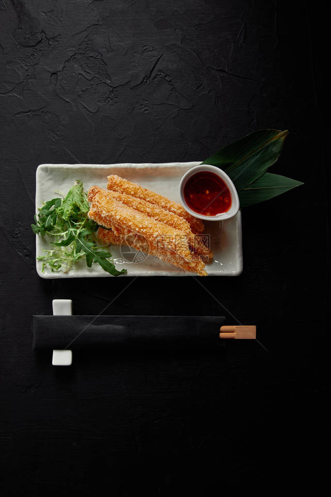 美味春卷配甜辣椒酱和筷子的顶视图图片