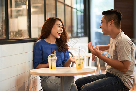 亚裔年轻夫妇在咖啡馆里玩着寒冷图片