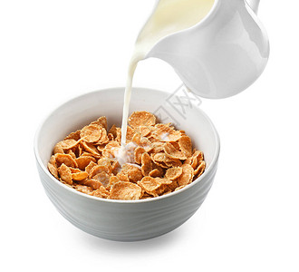 将牛奶倒入碗中白色背景上有健康的玉米片图片