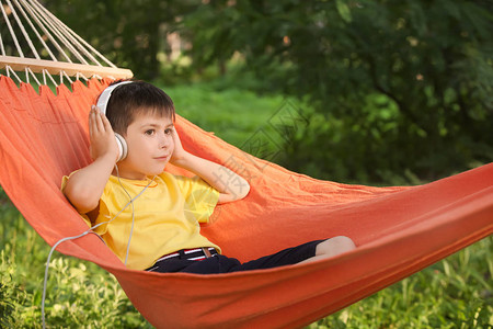 可爱的小男孩在夏日的吊床上放松图片