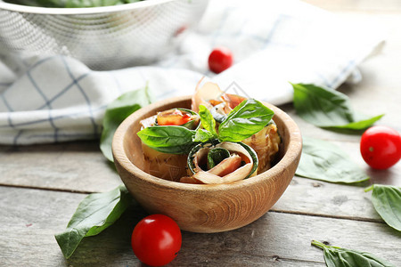 木桌上碗里的美味西葫芦卷和意大利熏火腿图片