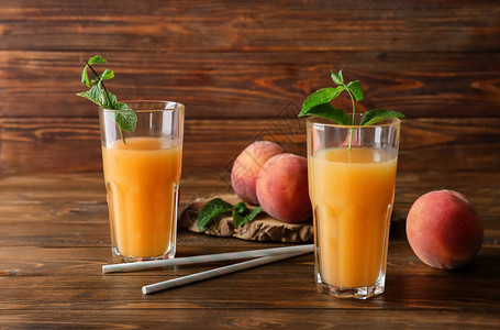 木桌上玻璃杯中的桃汁图片