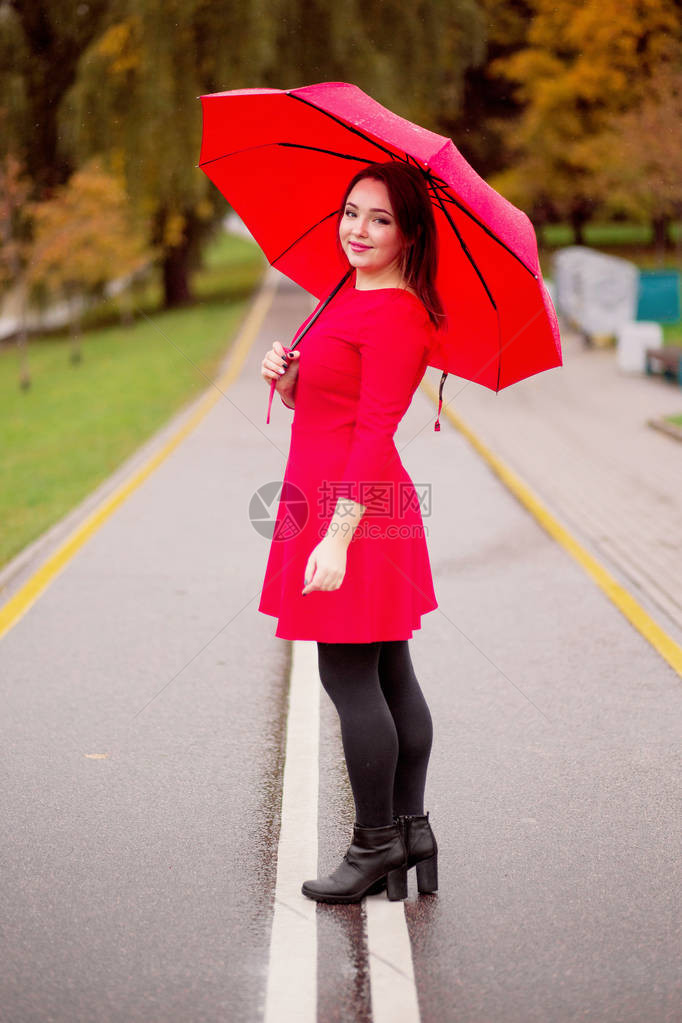 喜悦的女孩在秋天公园的雨伞图片