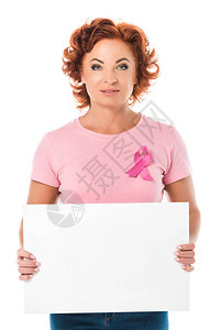 身穿粉色T恤戴着乳腺癌意识丝带的成熟女手持空白横幅图片