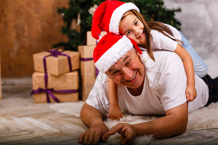 快乐的女孩和笑的爷在圣诞树图片