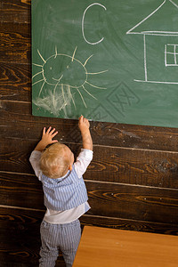 小男孩从教室的黑板上学习绘画图片