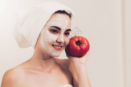 美丽的女人用番茄奶油提取物进行面膜治疗图片