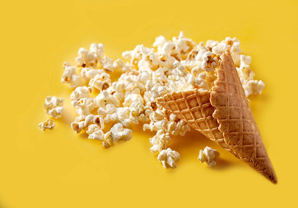 鲜黄背景的冰淇淋在华夫饼锥中吃爆米花电影图片