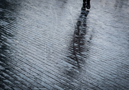 下雨后在伦敦潮湿街道上行走的未承认身份的图片