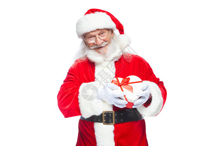 戴着白手套的微笑圣诞老人拿着一个红白相间的心形礼盒图片
