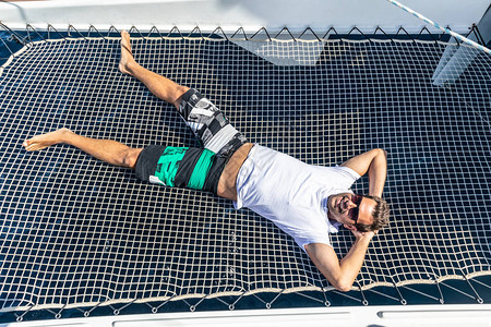 运动男子在放松躺在豪华航行度假的船舱背景图片