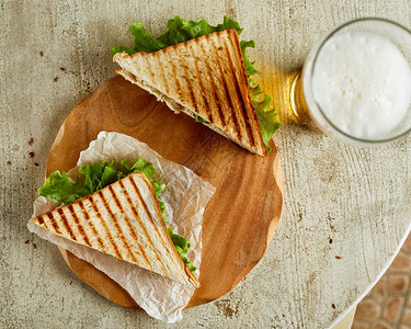 两份烤三明治的高角度视野以啤酒图片