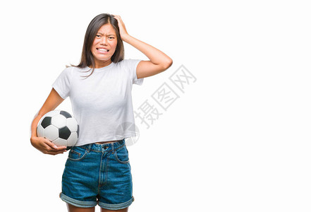 年轻的亚洲女子在与世隔绝的背景下拿着足球图片