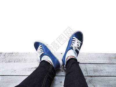 穿着蓝色运动鞋的自拍脚在木地板上与白色背景隔绝图片
