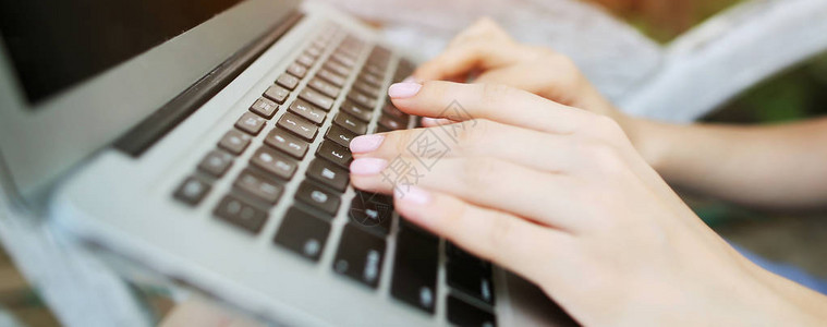 网站标题和女特写手在笔记本电脑键盘上打字的横幅图片
