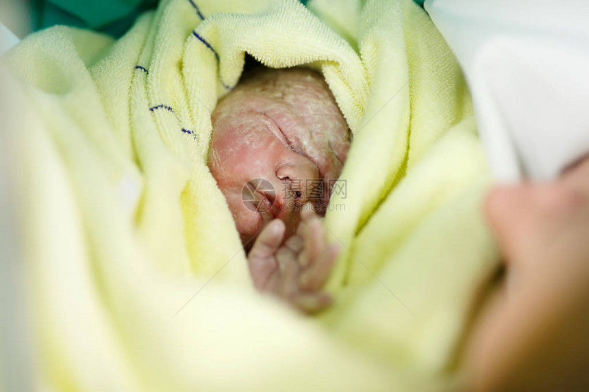 新生儿秒和年轻的母亲和出生后的分钟可爱的小新出生的女婴在毛巾上新生活图片