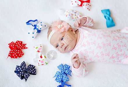 可爱的新生婴儿与五颜六色的蝴蝶结图片