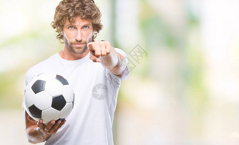英俊的西班牙裔男子模特在孤立的背景上拿着足球图片