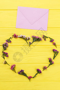 心形鲜花和邮政件黄色的木桌表面图片