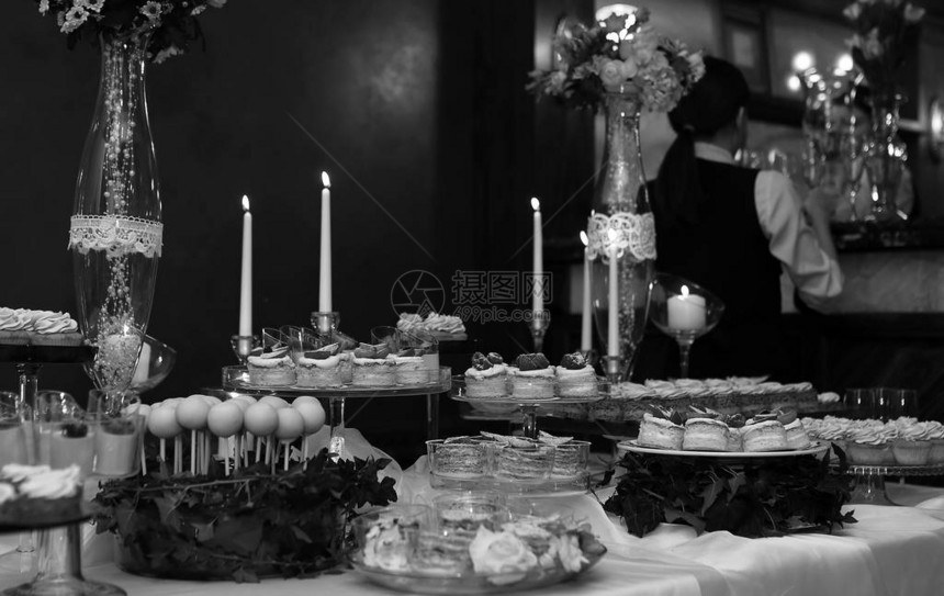 在女孩美食者的背景下装饰一个配有糖果和各种甜点的节日餐桌图片