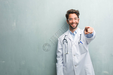 年轻友善的医生男子对抗墙壁图片