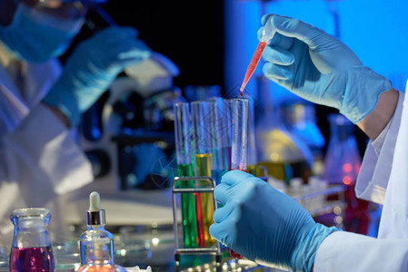 身戴橡胶手套的研究人员站立在实验室图片