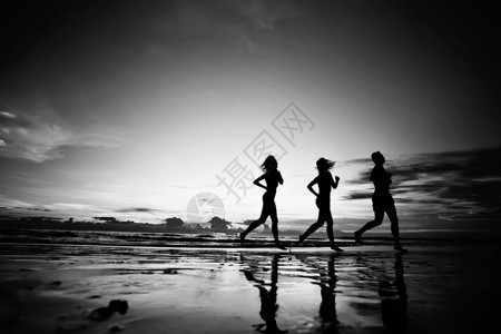 运动员沿海滩奔跑的剪影暑假图片