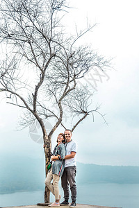 观赏一对情侣在美丽的白色天空上摆着的景象在巴厘岛印尼的悬崖图片