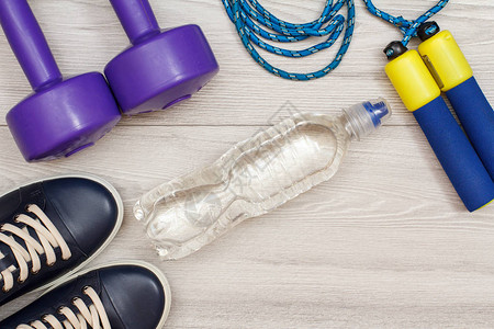 在灰地板的房间或健身房用瓶装水进行健身的图片
