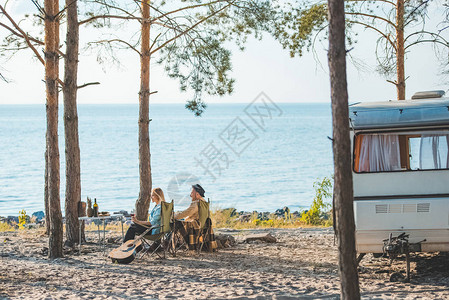 年轻夫妇在海边的露营车上野餐图片