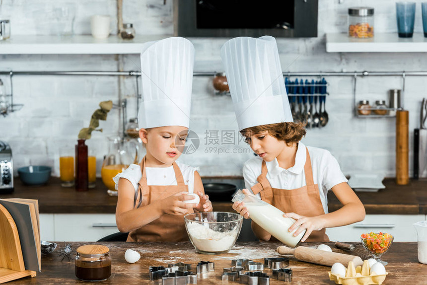 穿着厨帽和围裙的可爱孩子为厨房图片