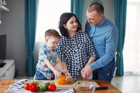 家母父亲和儿子在厨房的桌子上煮红绿图片
