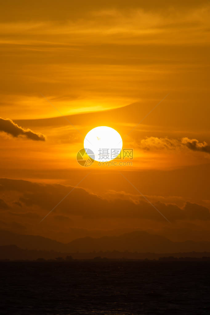 太阳在日落的天空和山顶的云层中图片