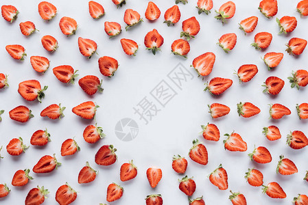 白色表面成熟减半草莓圆形框架的顶部视图图片