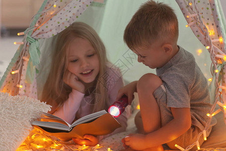 可爱的小孩在家里的小屋里看书图片
