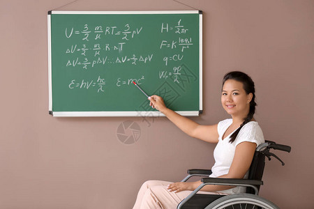 在学校黑板附近坐轮椅的女老师图片