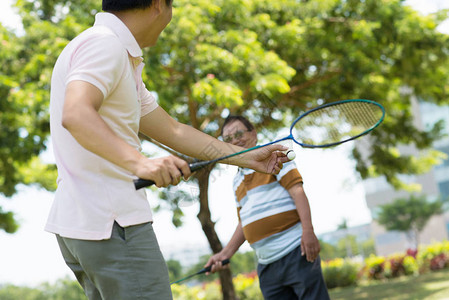 成年男子和父亲打羽毛球图片