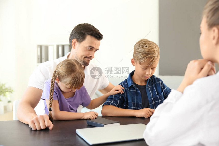 年轻男子及其子女在学校会见校长图片