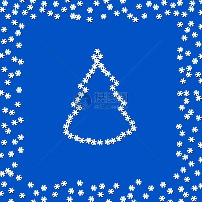 糖装饰以雪花的形式成圣诞树的轮廓雪花在蓝色背景上的散射与文本的空间最小的圣诞节图片
