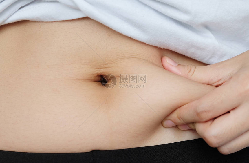 女人的手侧部抓着脂肪身体肚子肠糖图片
