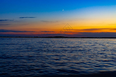 哈巴罗夫斯克阿穆尔河堤岸上的日落太阳从地平线上落下堤岸被灯笼照亮人们图片