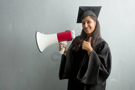 年轻毕业的印度女青年反对墙壁欢乐和兴奋图片