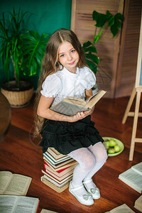 拥有长金发书本校董会和苹果的幼年班级甜蜜女学生图片