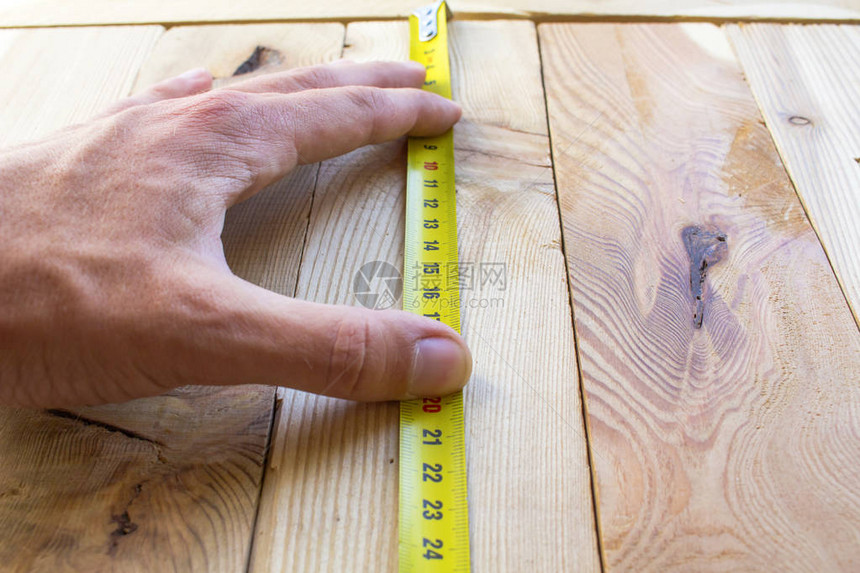 用卷尺在木板上测量图片