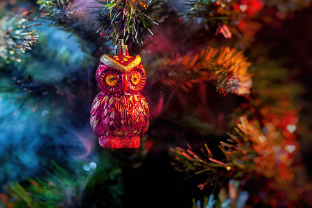 红色闪亮的装饰圣诞球猫头鹰与彩色紫红色烟雾中的房子图片